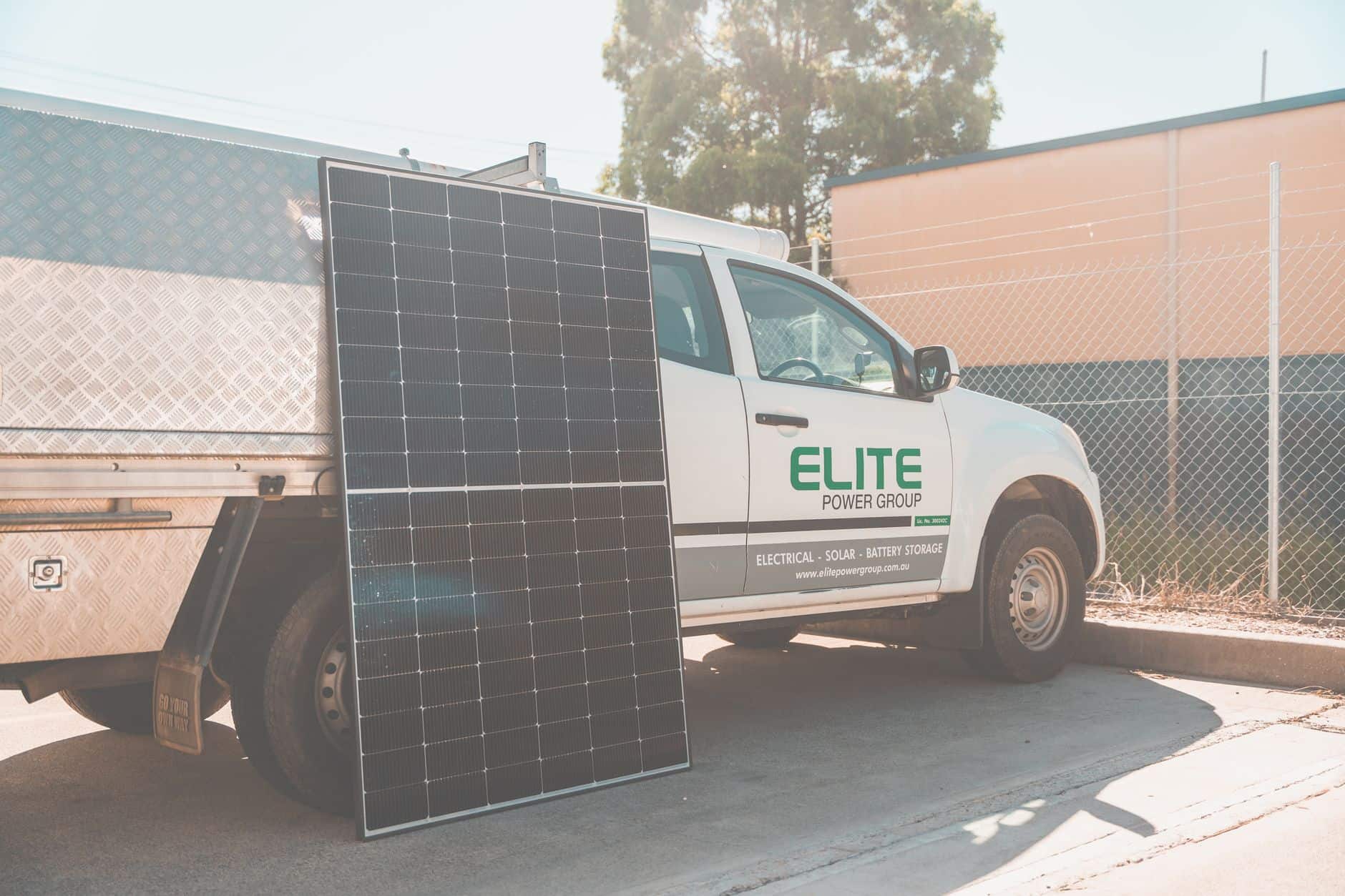 Solar panel leaning against a utility truck at a clean energy installation site