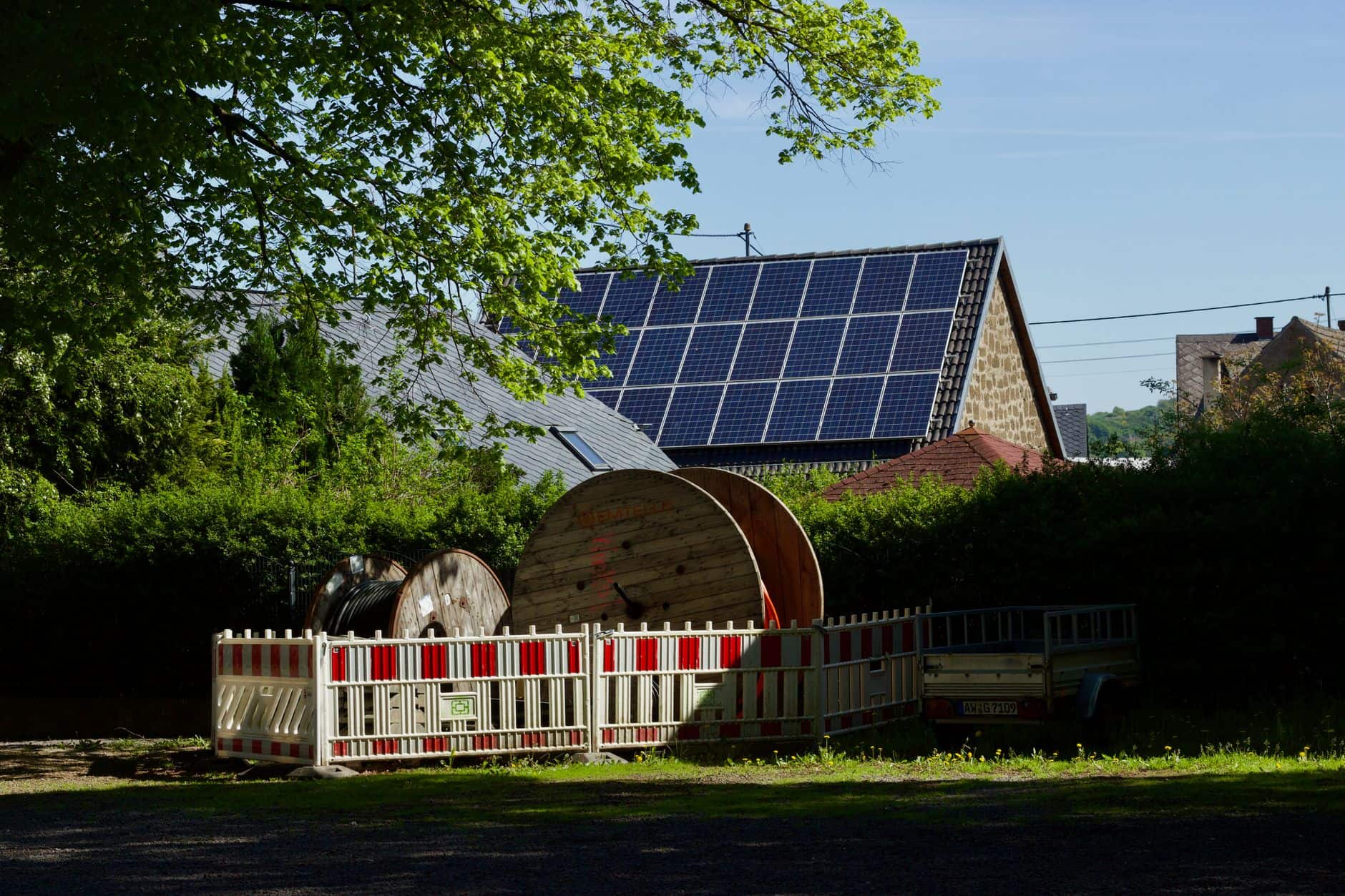 Barn with solar panels and cable reels in a rustic countryside setting