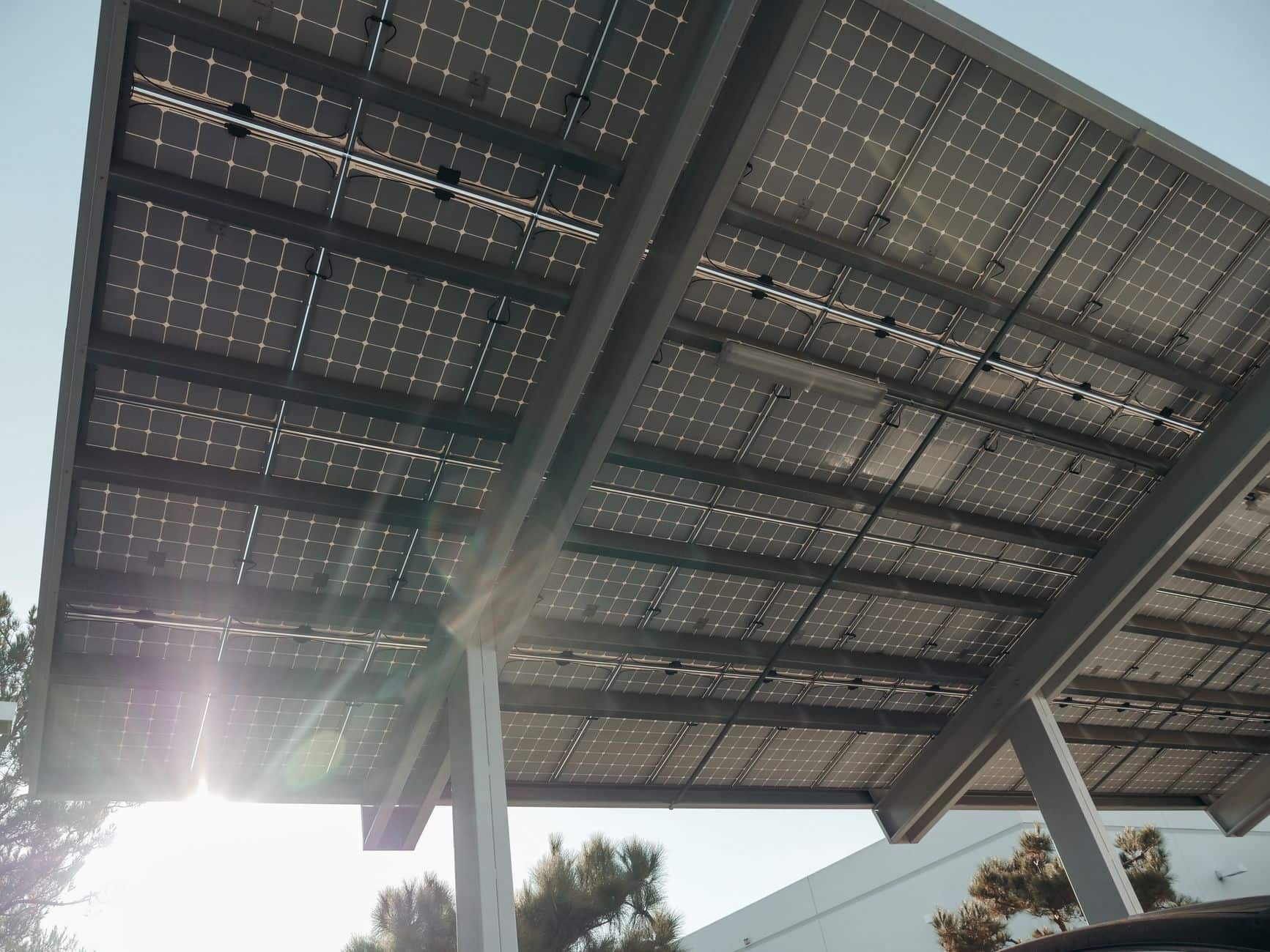 Close-up of modern solar panels mounted on a metal frame with sunlight filtering through