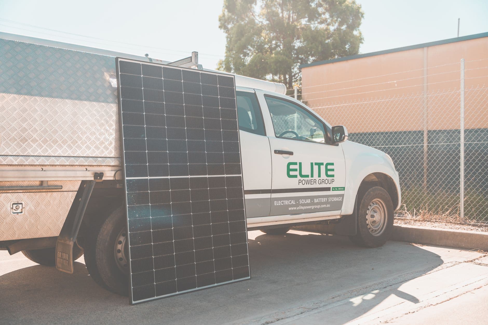 Solar panel leaning against a utility truck at a clean energy installation site