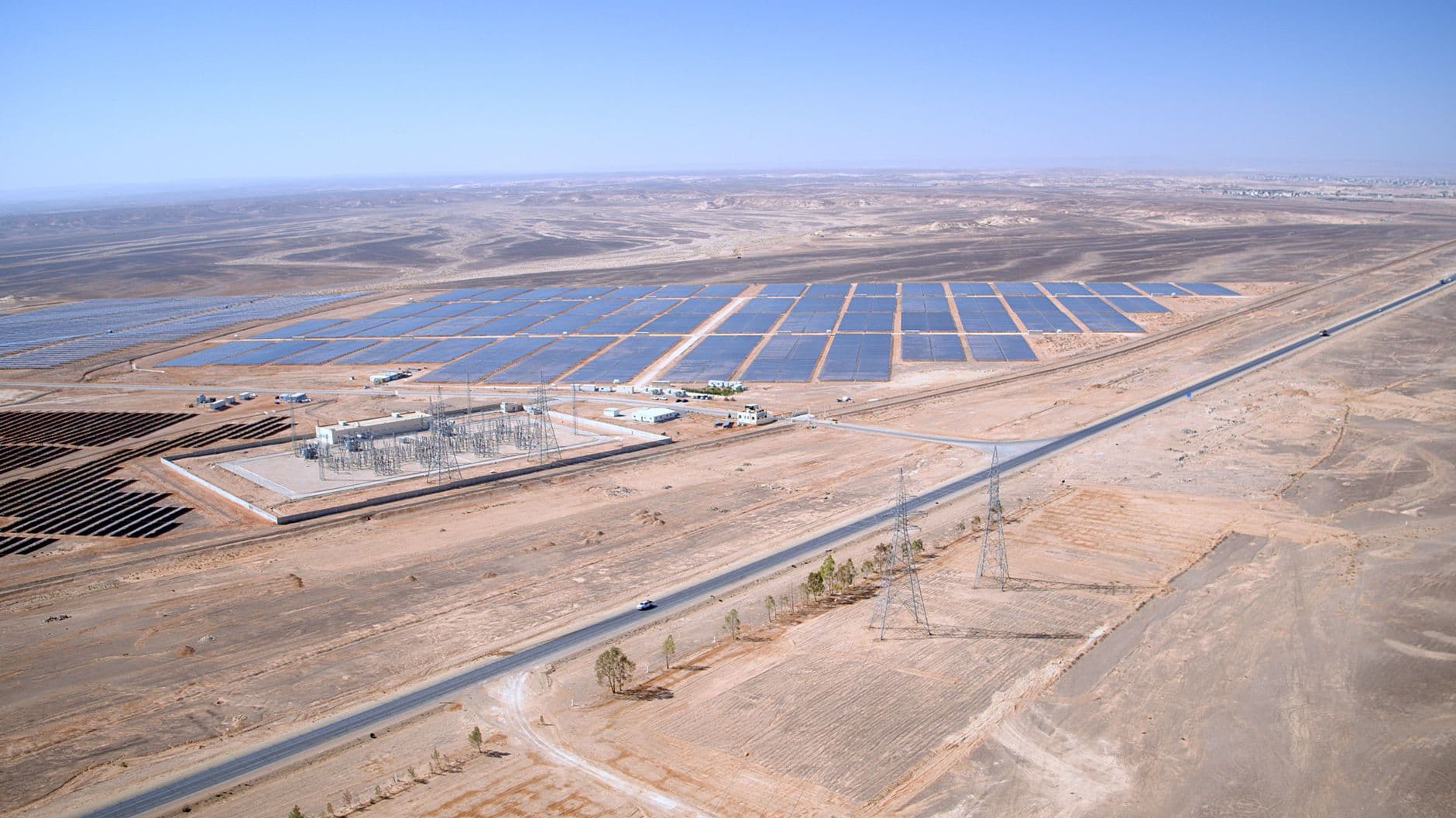 Aerial view of a large solar farm with rows of photovoltaic panels