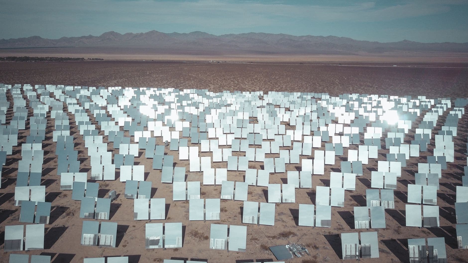 Aerial view of a large solar panel field in a sunny desert landscape