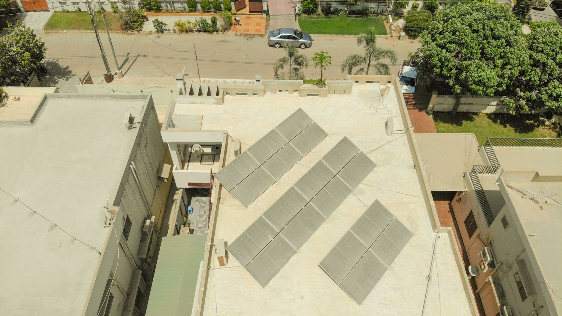 Aerial view of rooftop solar panels on a building in Karachi, Pakistan, showing a solar installation in an urban setting.