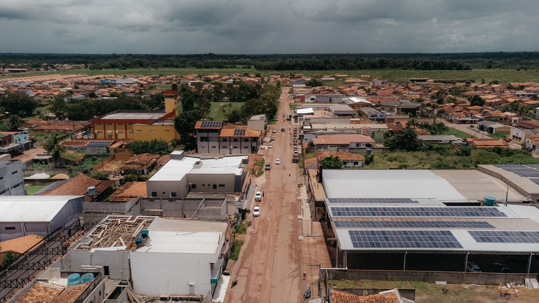 Aerial view of a town with solar panels on rooftops and surrounding landscape
