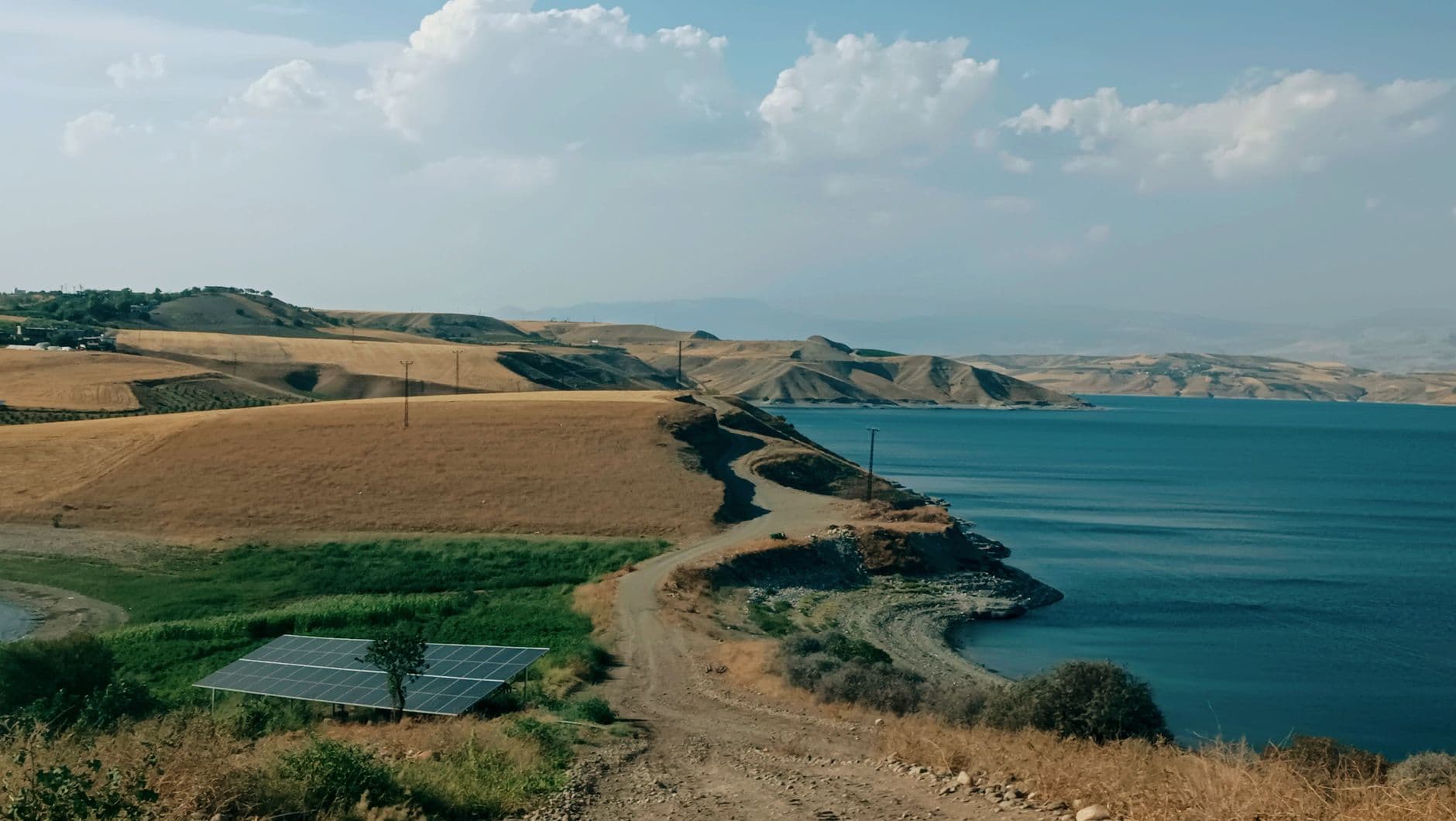 Aerial view of solar panels installed on a lake surface near a shoreline