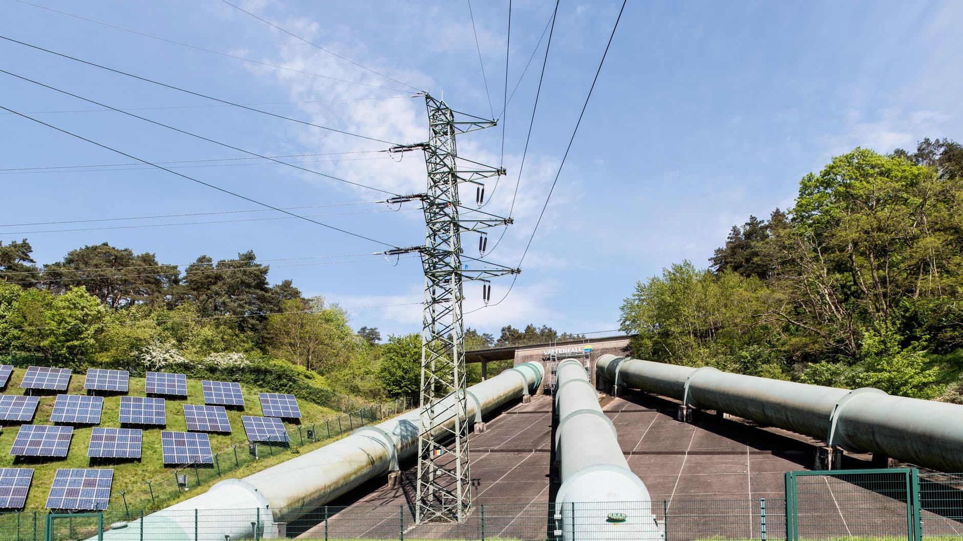 Industrial landscape in Geesthacht, Germany with a transmission tower, pipelines and rows of solar panels
