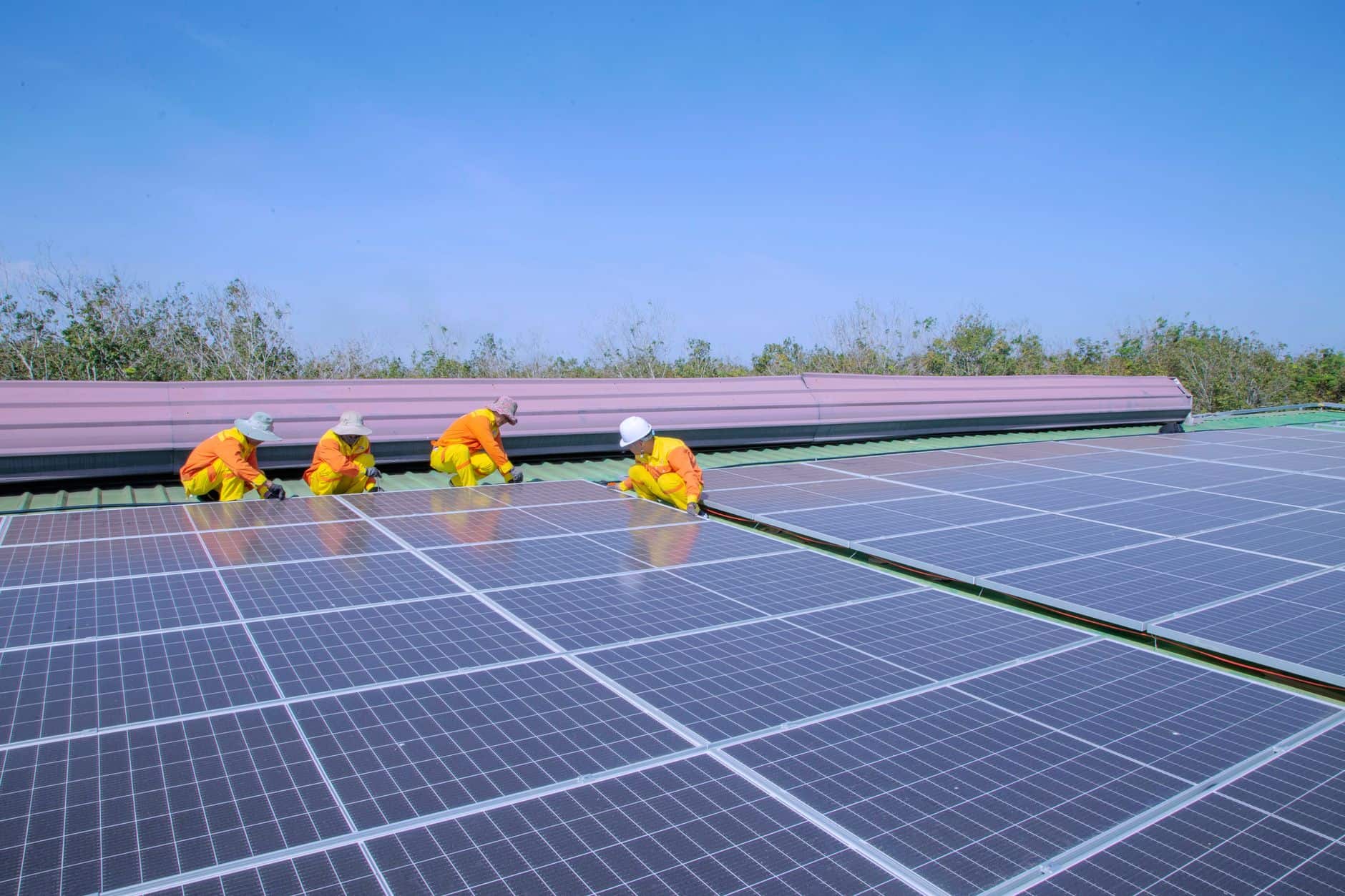 Workers installing solar panels on a sunny day