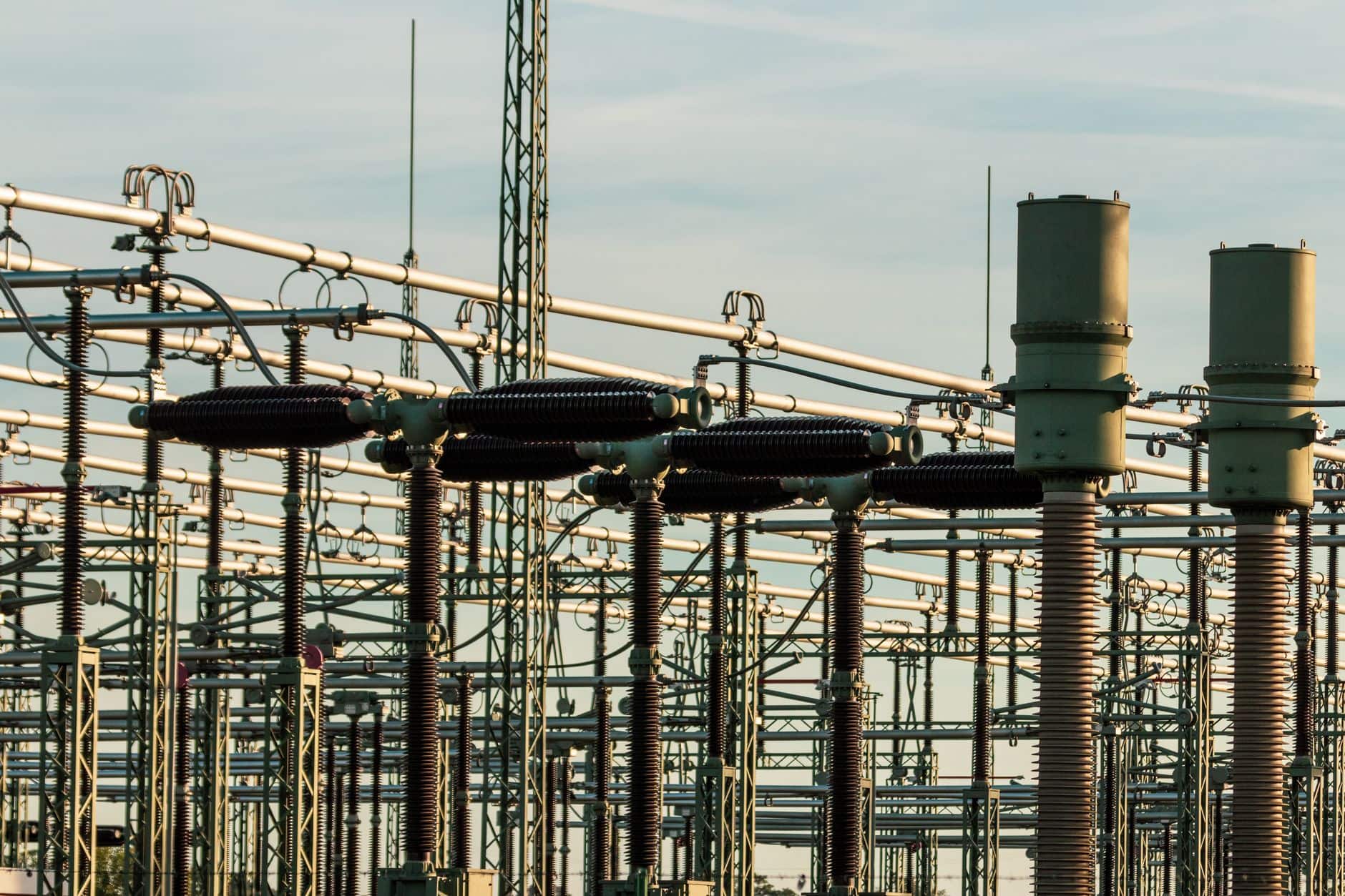 Electrical substation with high‑voltage equipment and insulators against a clear sky