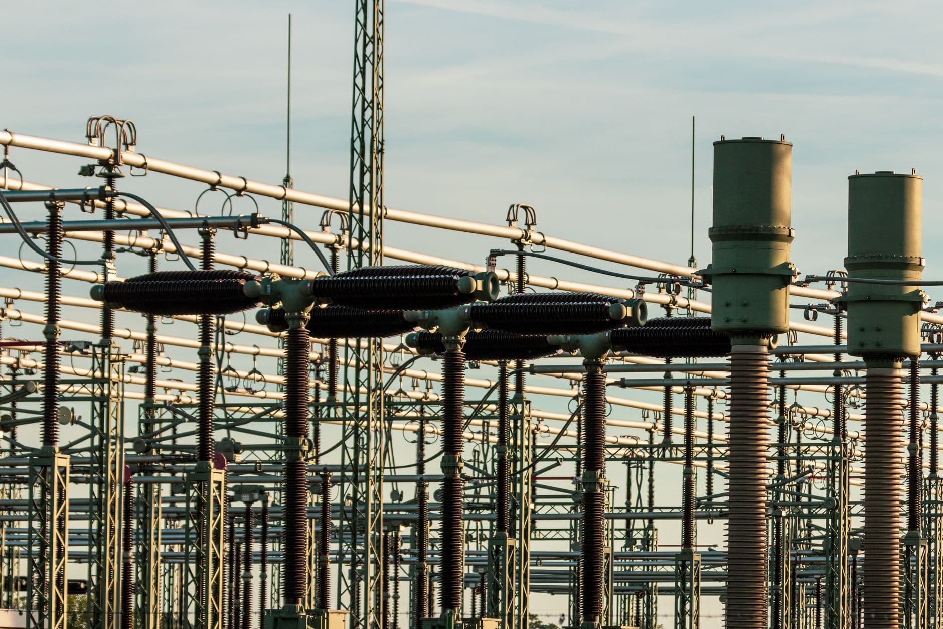 Electrical substation with high‑voltage equipment and insulators against a clear sky