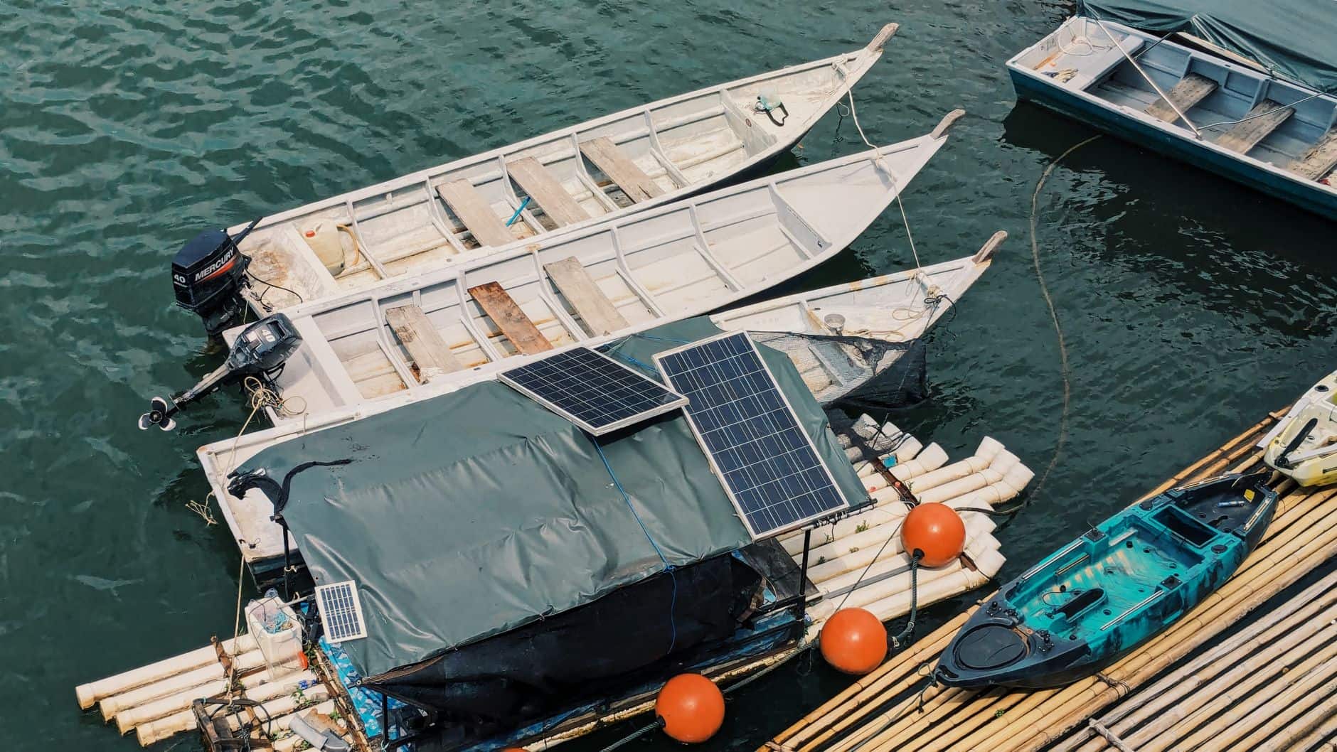 Aerial view of boats moored on a lake with solar panels installed on the water