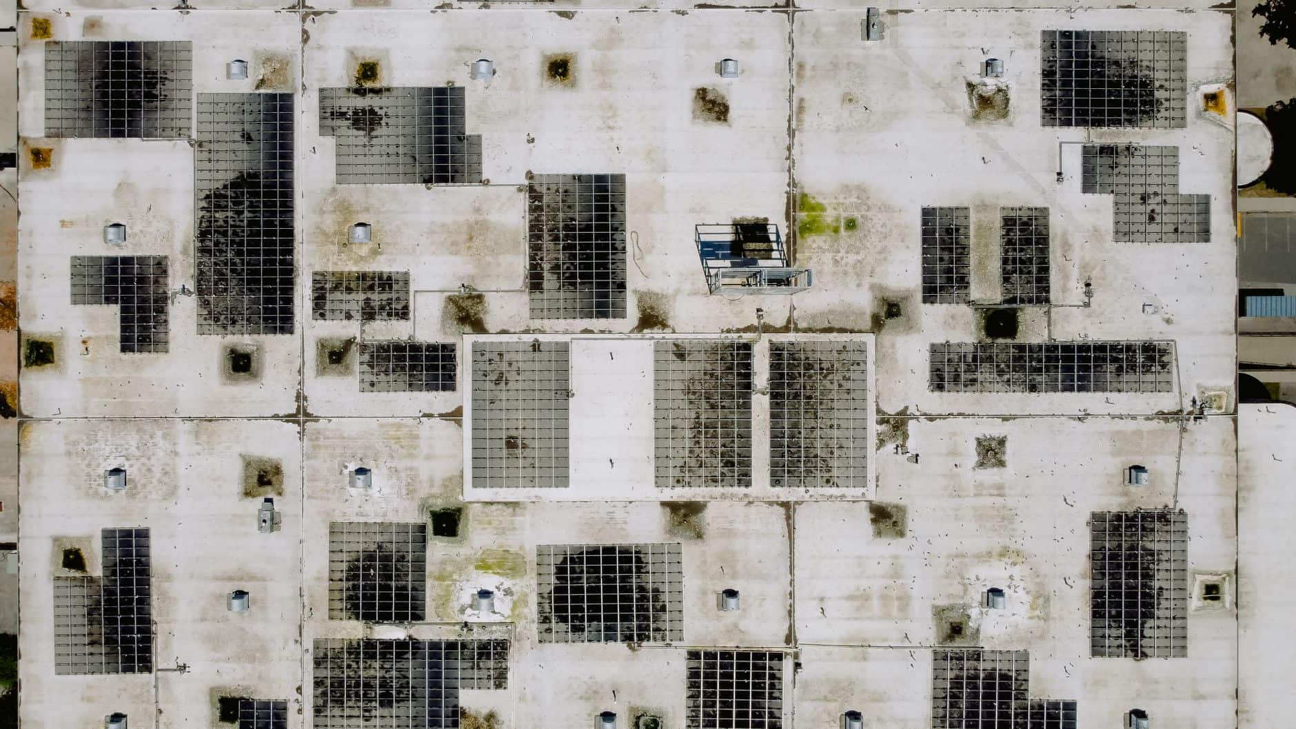 Aerial view of an industrial rooftop covered with solar panels