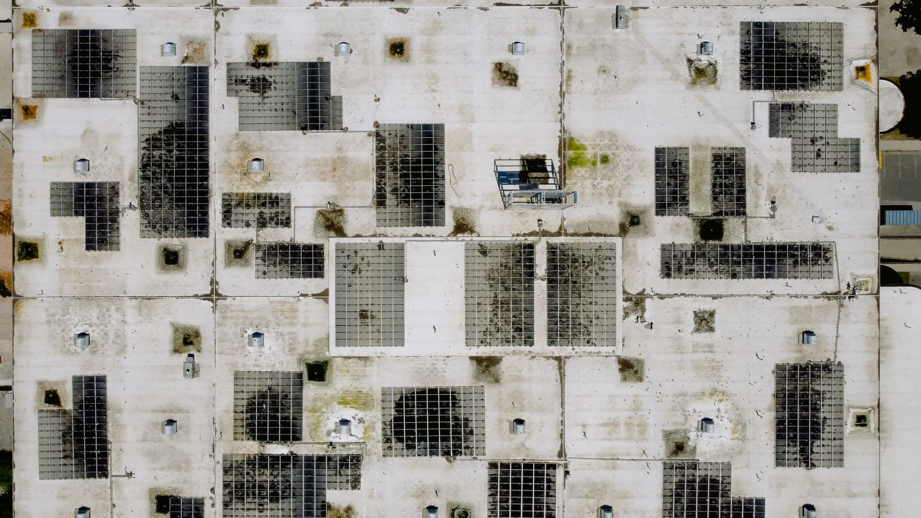 Aerial view of an industrial rooftop covered with solar panels