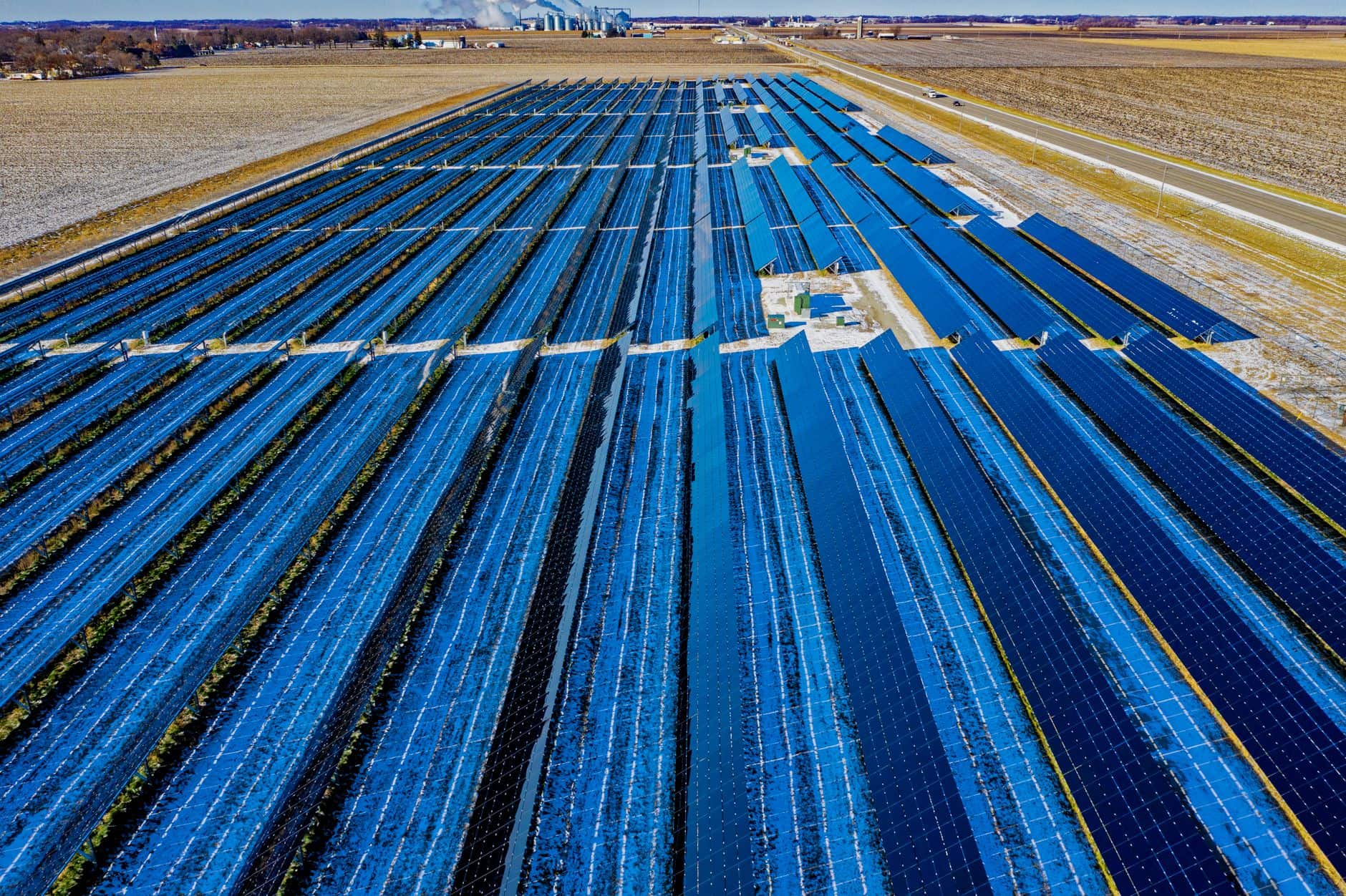 Aerial view of a large solar farm with rows of photovoltaic panels