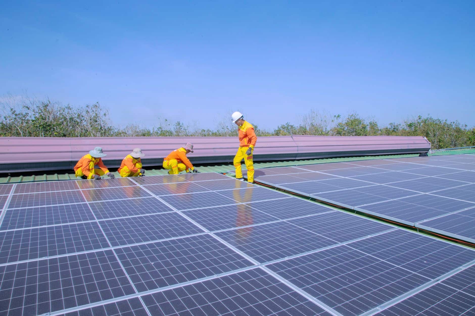 Workers installing solar panels on a rooftop