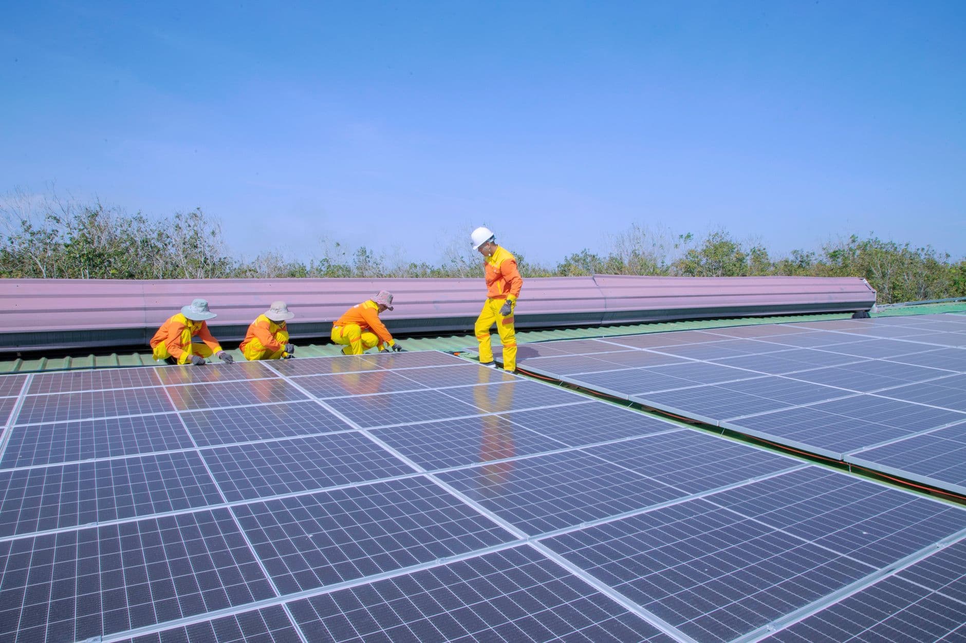 Workers installing solar panels on a rooftop