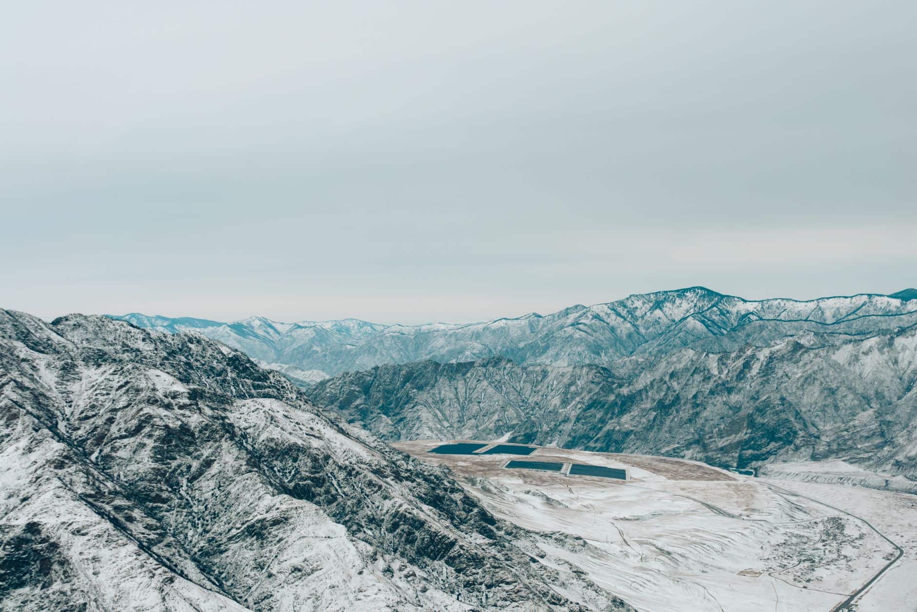 Aerial view of solar panel arrays on snow-covered mountains