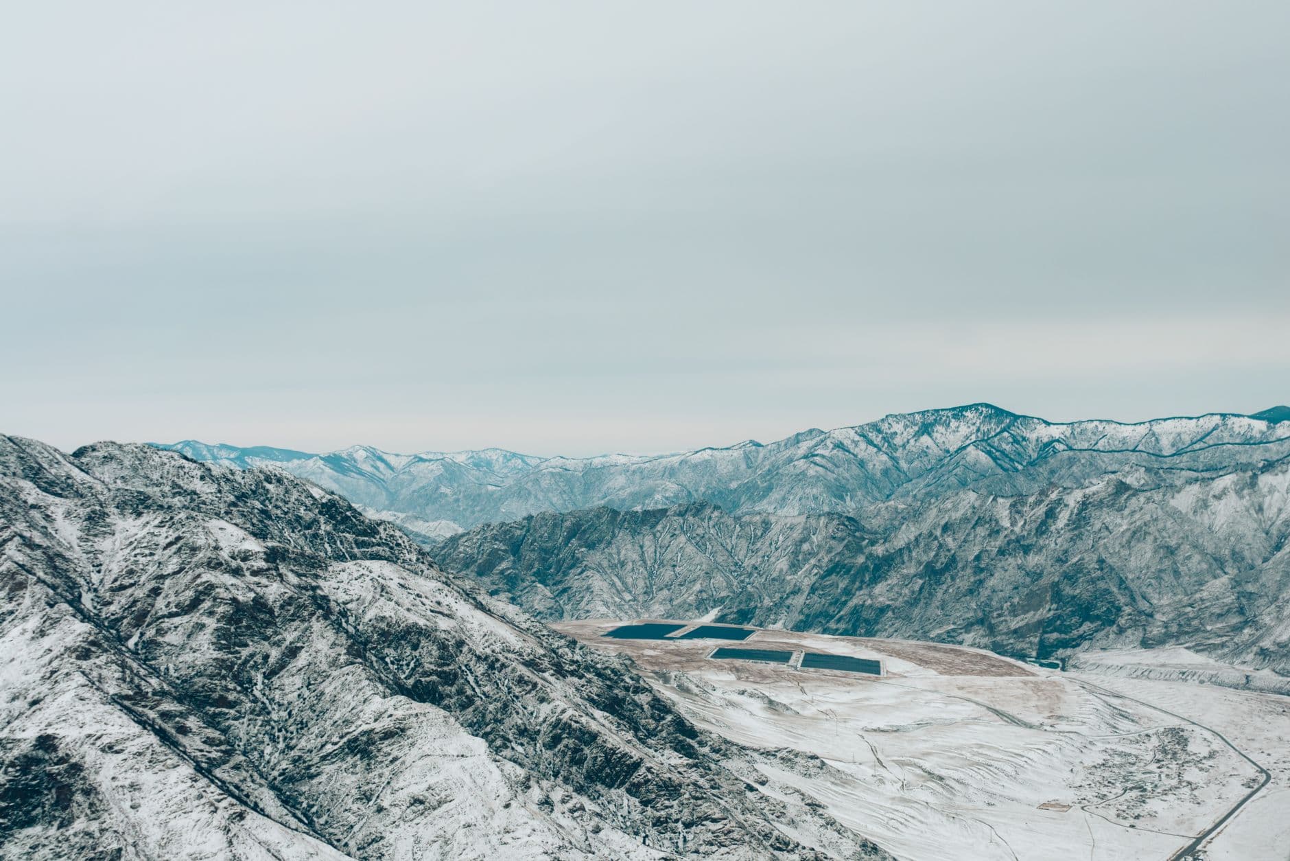 Aerial view of solar panel arrays on snow-covered mountains