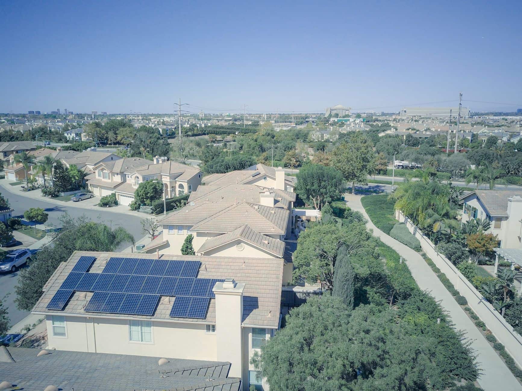 Aerial view of a suburban neighborhood with rooftop solar panels highlighting clean renewable energy