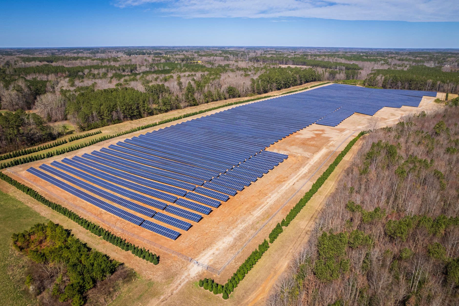 Aerial view of a large solar panel farm in a rural North Carolina landscape