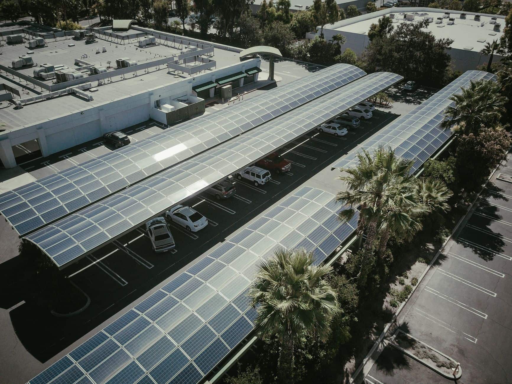 Aerial view of a parking lot covered by solar panel canopies (carports) showcasing clean energy usage