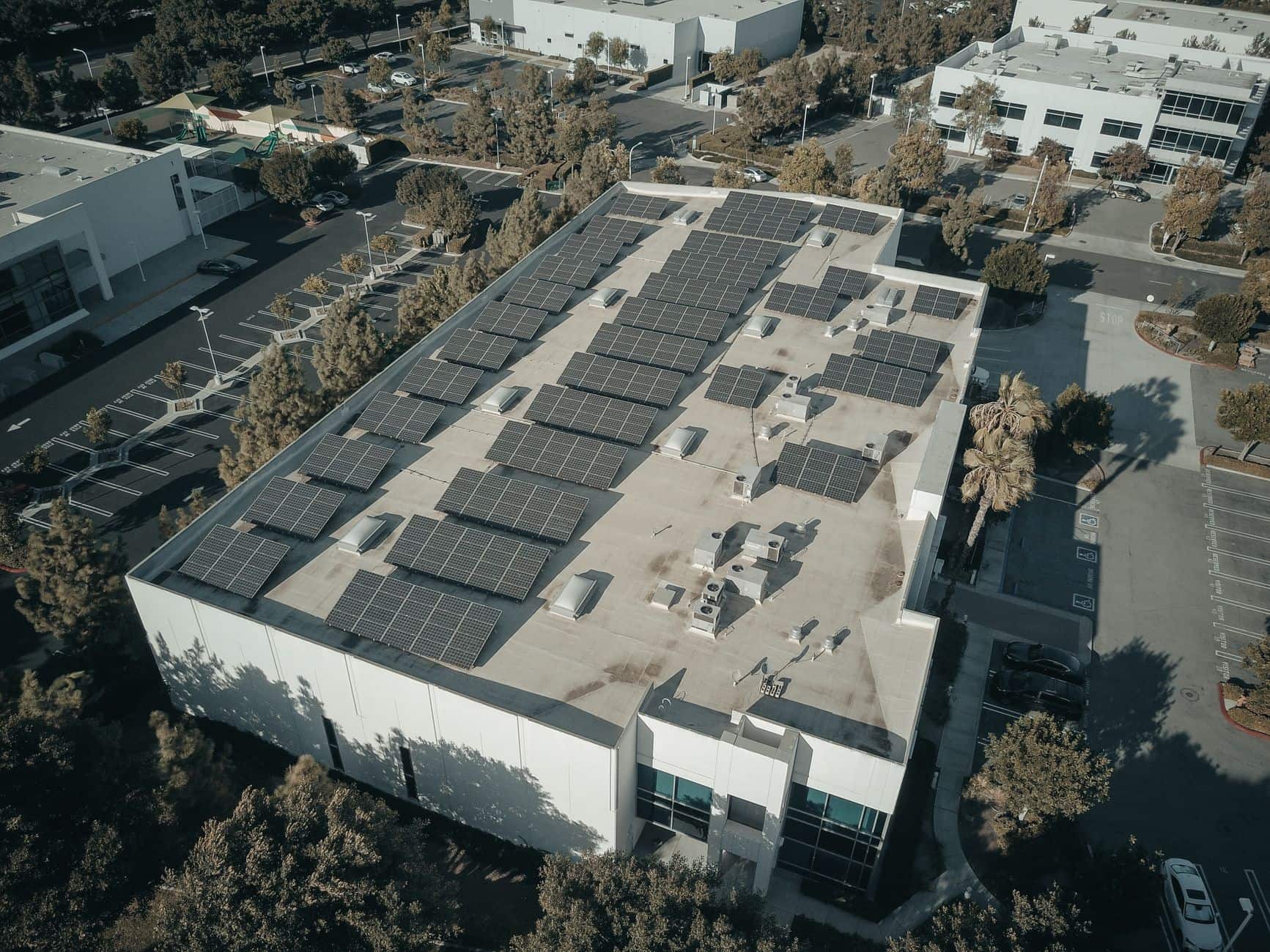 Aerial view of a commercial building rooftop covered with solar panels