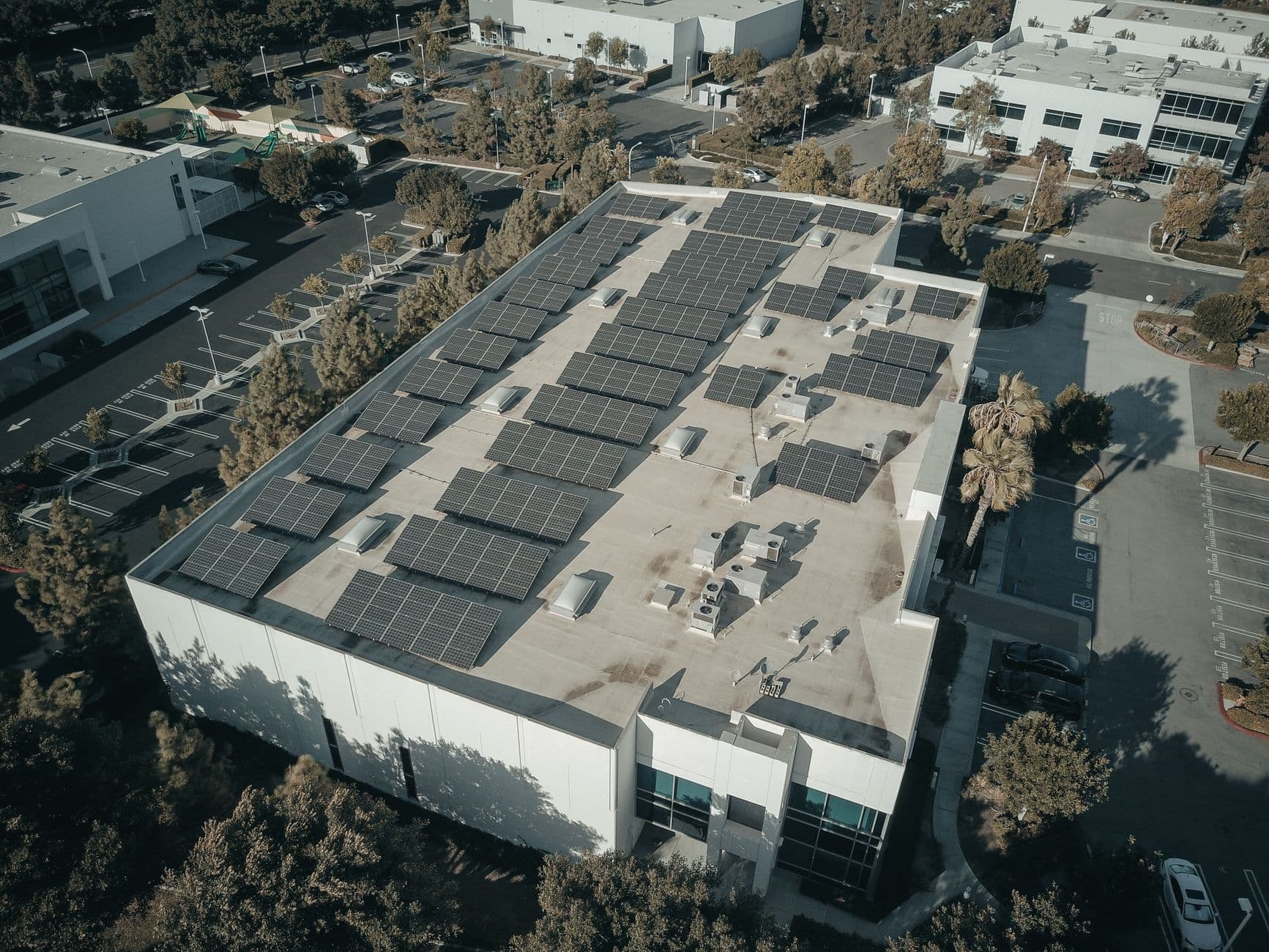 Aerial view of a commercial building rooftop covered with solar panels