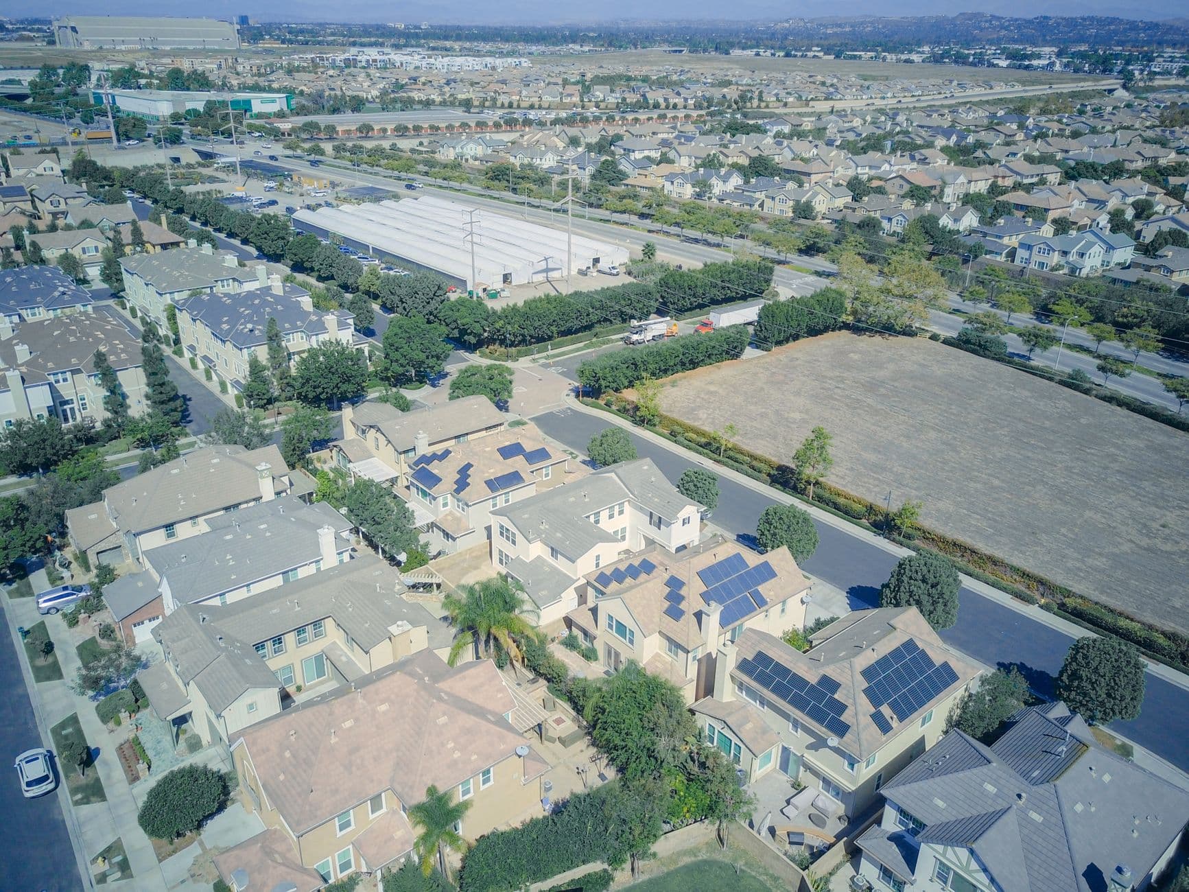 Aerial view of a suburban neighborhood showing rooftops equipped with solar panels