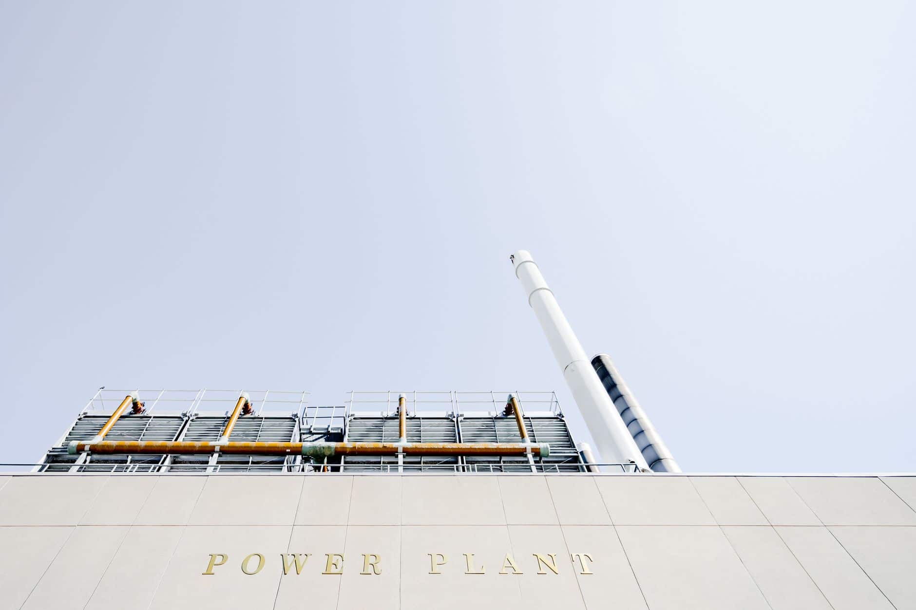 Modern power plant exterior with smokestacks under a clear sky
