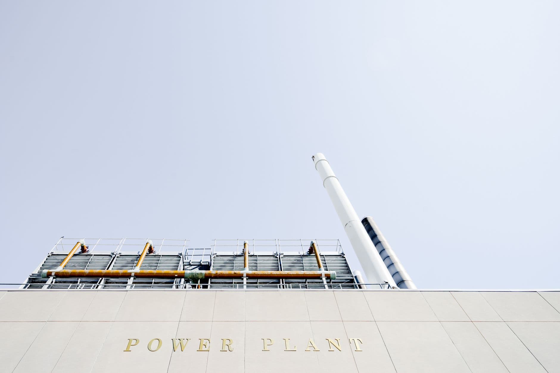 Modern power plant exterior with smokestacks under a clear sky