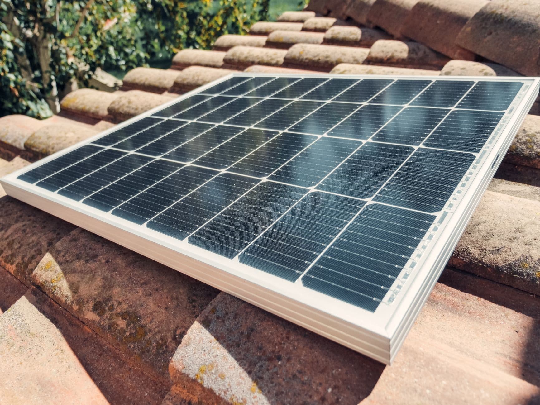 Close-up of rooftop solar panels on tiled roof under bright daylight