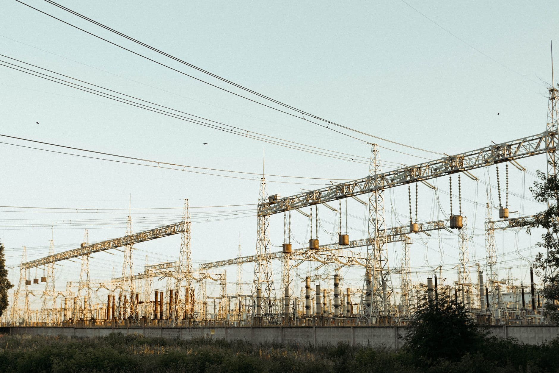 Wide view of an industrial electrical substation with power lines and transmission towers