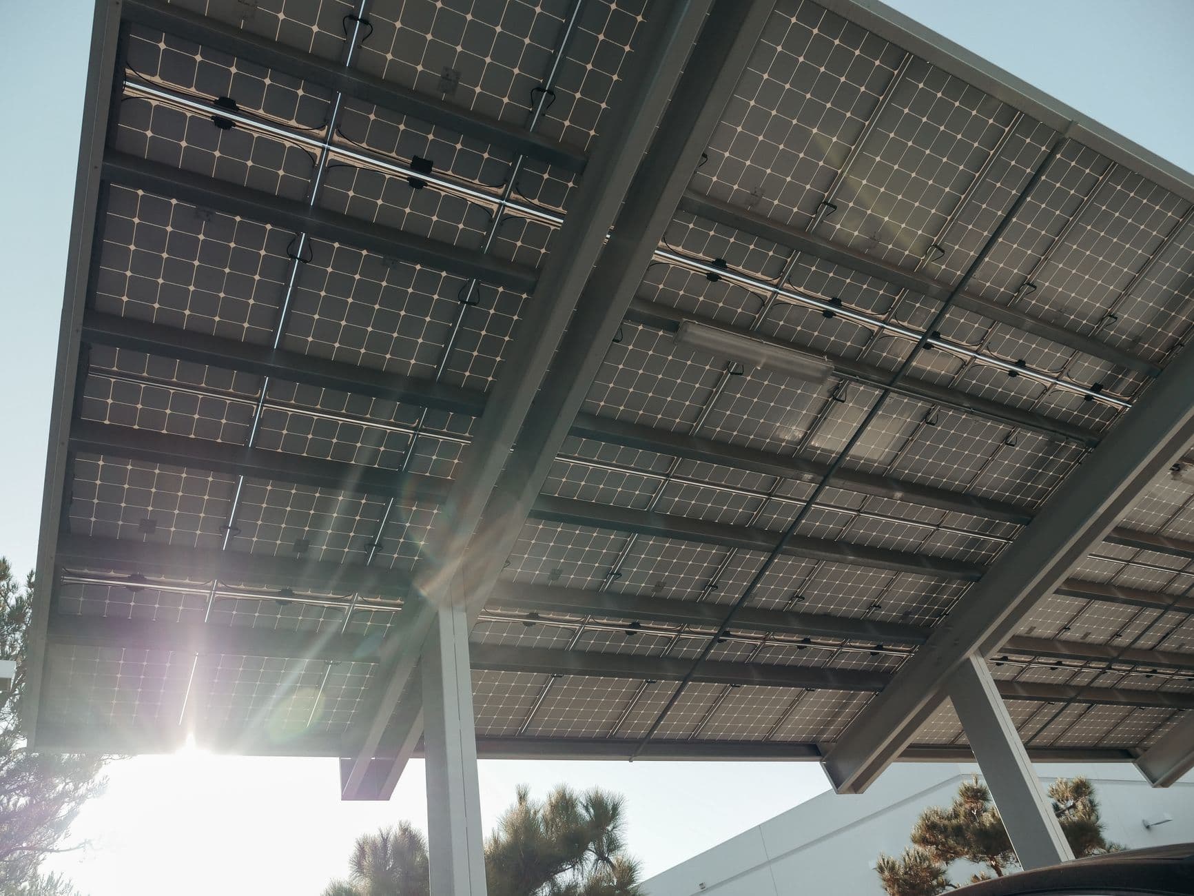 Close-up of modern solar panels mounted on a metal frame with sunlight filtering through
