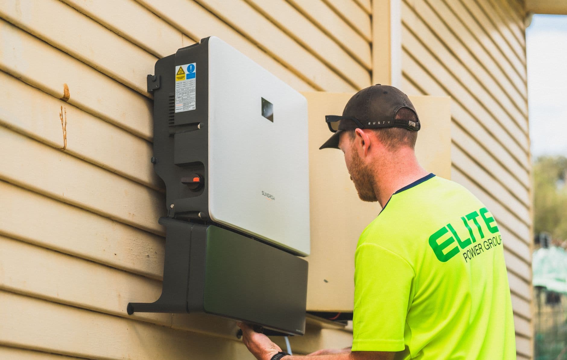 Technician installing a solar inverter system on a rooftop