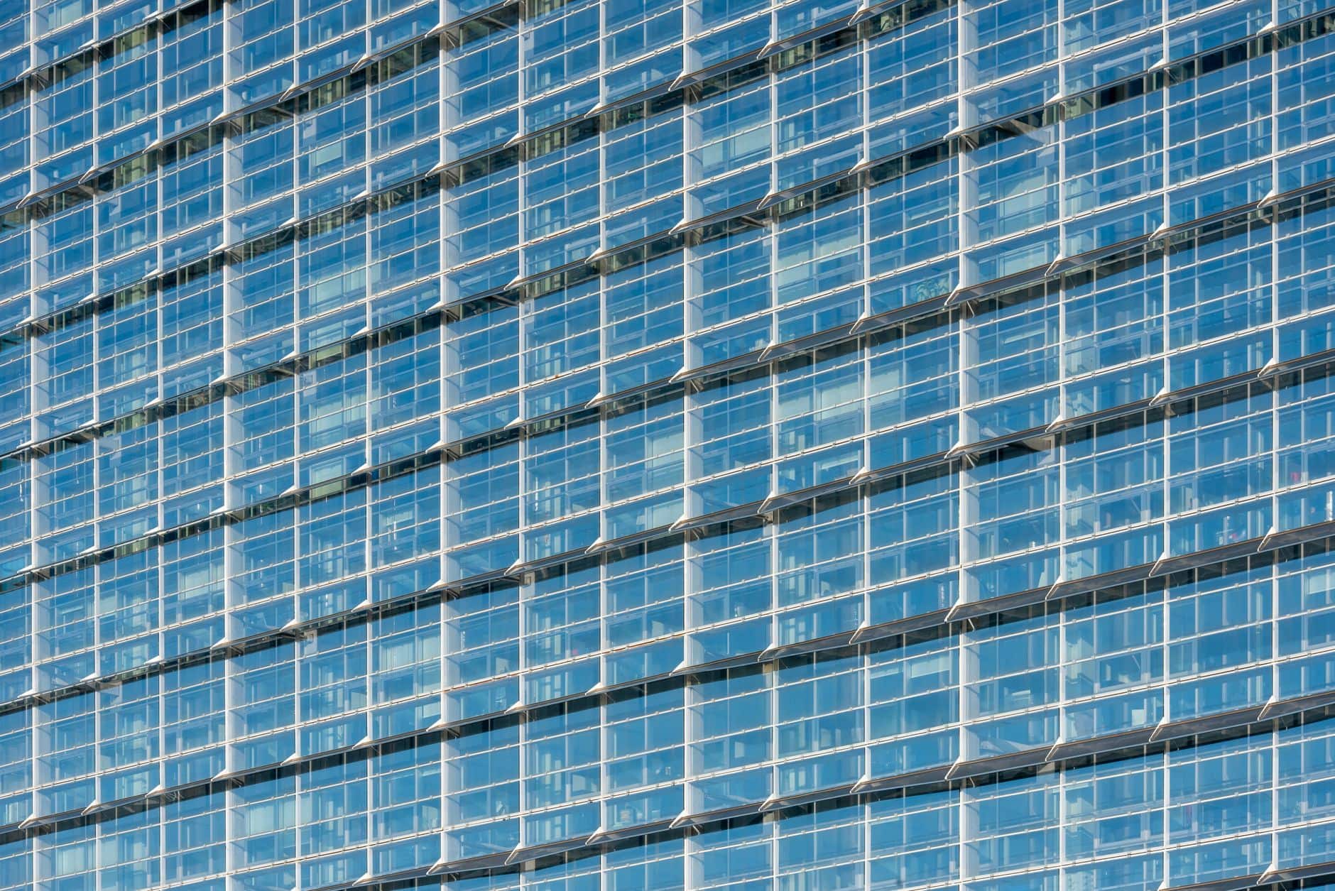 Elegant glass facade of a high-rise building reflecting the sky